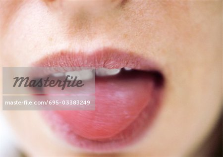 Close up of woman's mouth with tongue sticking out.