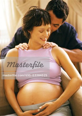 Man massaging pregnant woman's shoulders