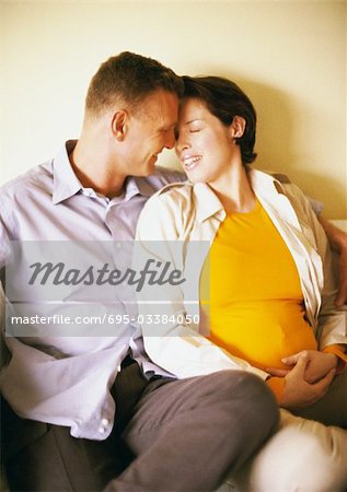 Man and pregnant woman sitting and smiling at each other