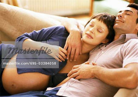 Tête de femme enceinte penchée sur la poitrine de l'homme, sur le canapé