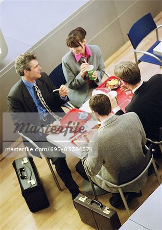 Business people having lunch on trays, elevated view