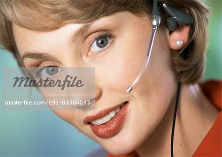 Femme portant des écouteurs, regardant la caméra, gros plan, portrait