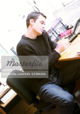 Homme assis au comptoir au bureau