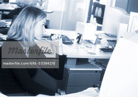 Frau sitzt am Computer, Seitenansicht, b&w