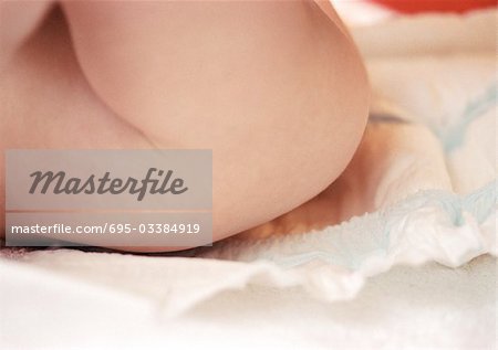 Baby having diaper changed, mid-section, side view, close-up