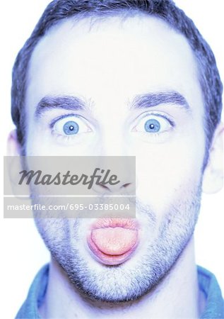 Man sticking out tongue, close-up, portrait