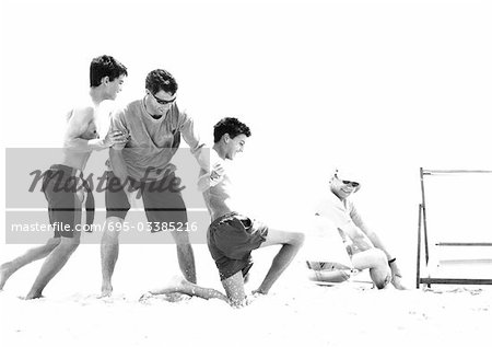 Family playing on beach, b&w