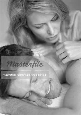 Man and woman lying on bed, close-up, b&w