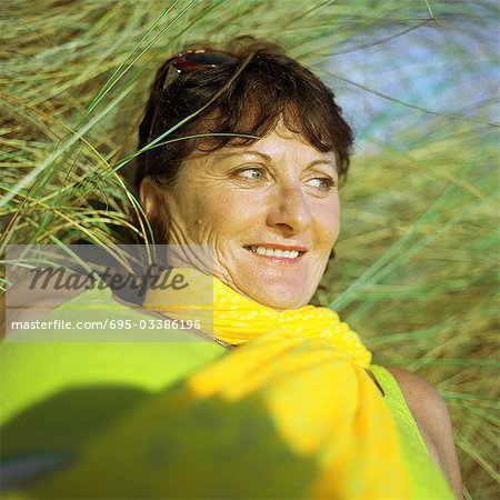 Reife Frau liegend im Gras, Porträt