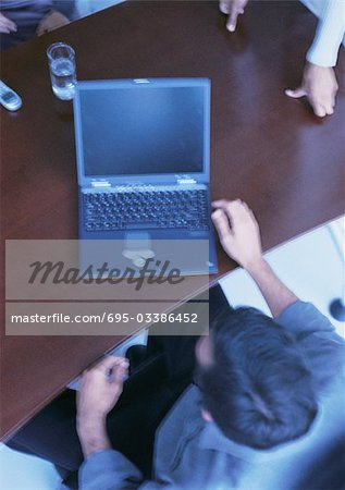 Businessman sitting at desk with laptop computer, elevated view