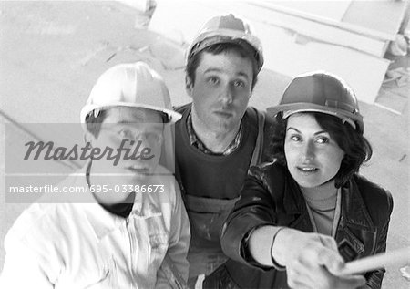 Two men and woman wearing hard hats, elevated view, b&w