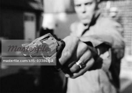 Man holding gun, close-up, b&w