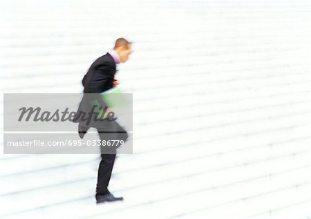 Businessman running down steps, side view, blurred motion