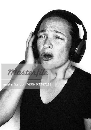 Woman listening to headphones and singing, portrait
