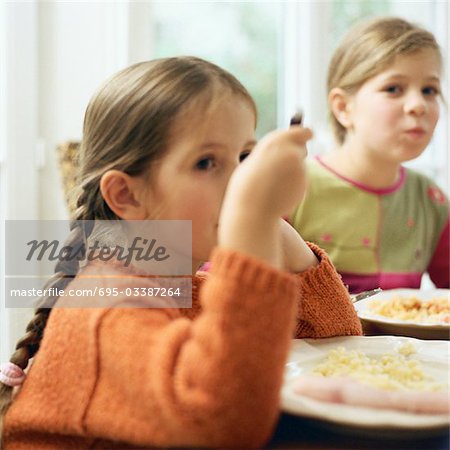 Deux filles assis à table, manger