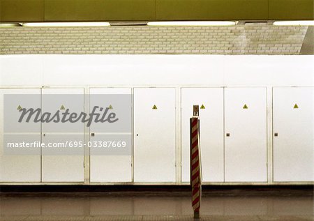 Row of doors enclosing electrical equipment in subway station