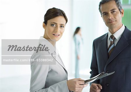Businessman and businesswoman standing with file