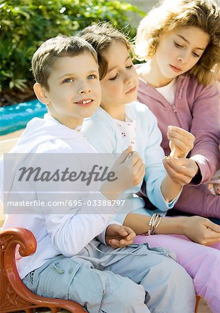 Enfants assis sur un banc à l'extérieur