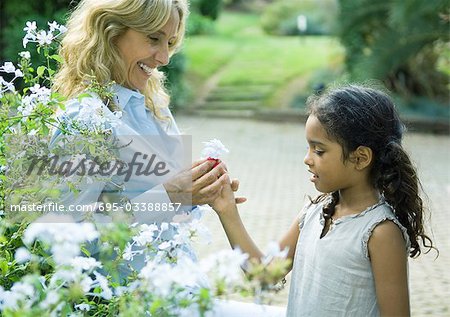 Mature woman handing granddaughter flower