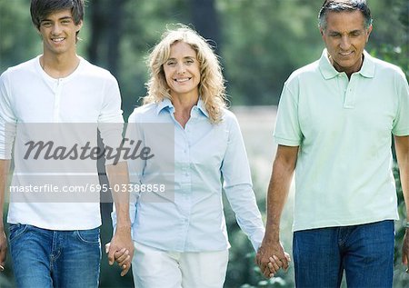Mature couple holding hands with teenage grandson