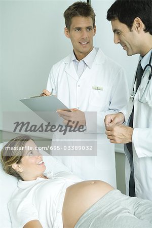 Zwei Ärzte im Gespräch mit der schwangeren Frau