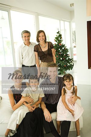 Three generation family, group portrait in front of Christmas tree