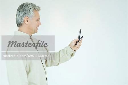 Homme d'âge mûr en regardant cell phone, vue latérale