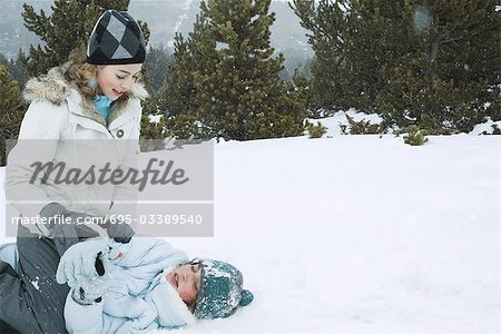 Two teen girls playfighting in snow