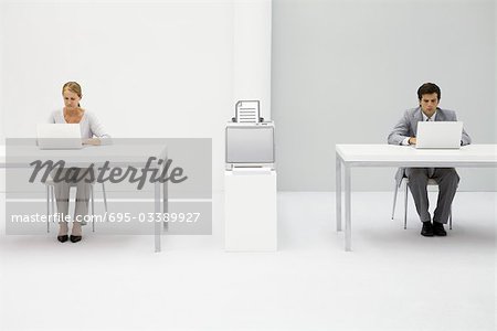 Colleagues in office using laptop computers, printer between them with graphic of document