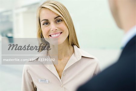 Woman wearing nametag smiling at camera