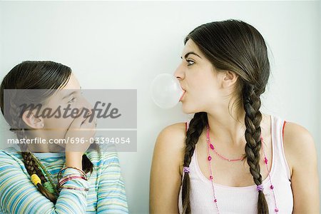 Deux jeunes amis, une bulle de soufflage tandis que les autres montres et couvre la bouche