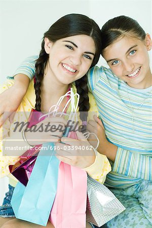 Two young female friends, one holding gift bags