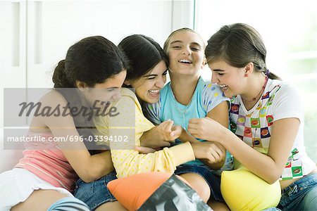 Quatre jeunes amis chatouiller les uns des autres et de rire