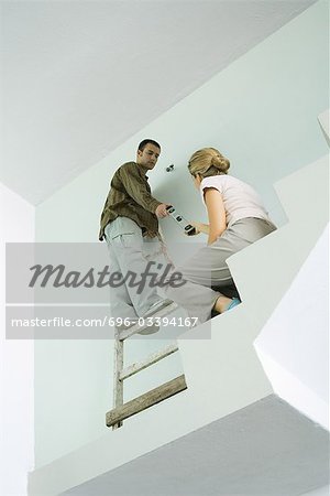 Woman handing man level, low angle view