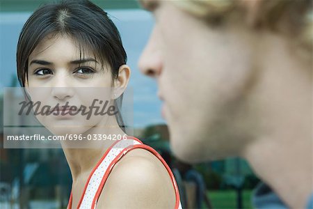 Young woman looking at young man in blurred foreground