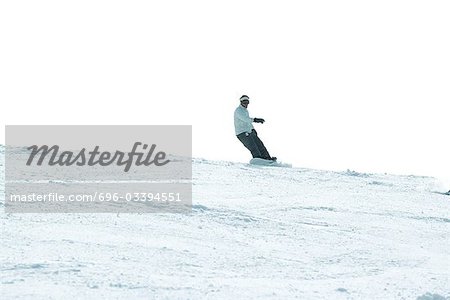 Surfeur des neiges sur la piste de ski, pleine longueur, au loin