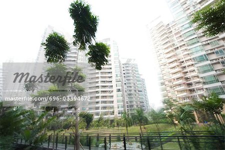 China, Guangdong Province, Guangzhou, high rise apartments and park, blurred motion