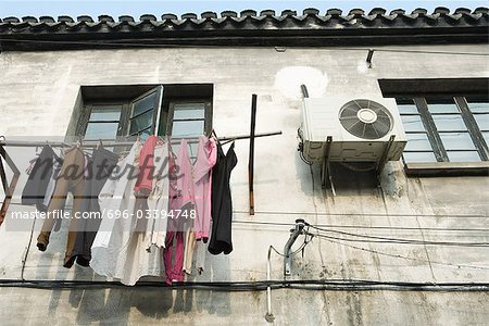 Laundry hanging out to dry below window, low angle view