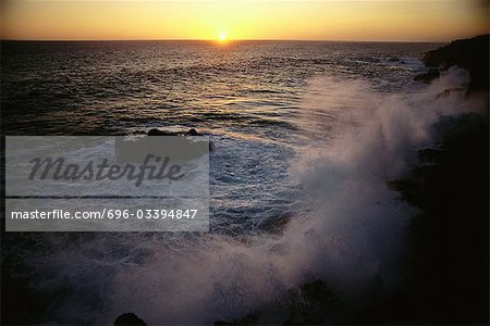 Waves crashing at sunset