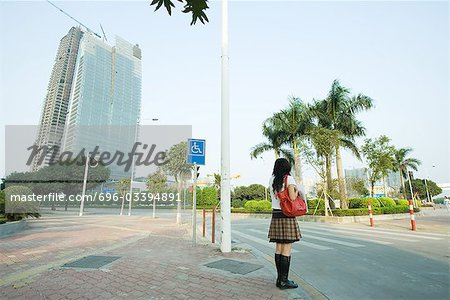 Jeune femme attendant de traverser la rue