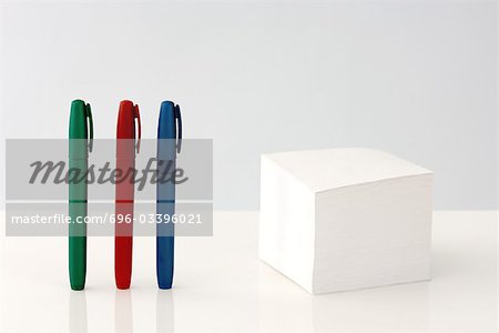 Selbstklebende Kurznotizstapel, bunte Stifte stehen in einer Zeile in der Nähe