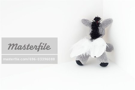 Stuffed elephant toy with wings, in the corner