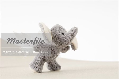 Stuffed elephant toy with wings trying to fly