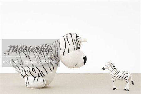 Tigre jouet face à zebra jouet, vue latérale
