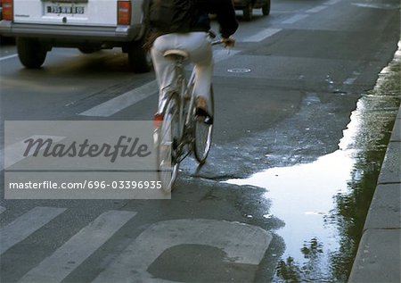 Wasserpfütze auf der Straße mit Verkehr