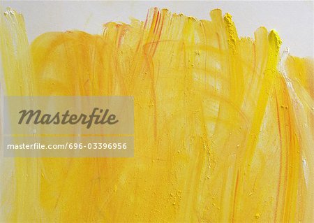 Yellow paint strokes on white paper, close-up, full frame