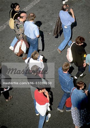 Group of people standing on asphalt, high angle view