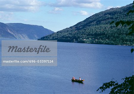 Les gens en bateau à rames près de fjords de la Norvège