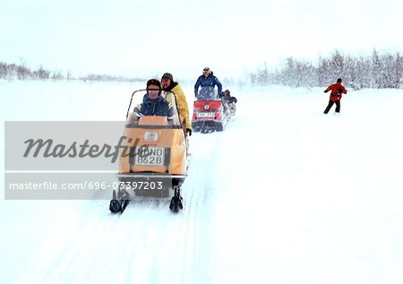 Schweden, Menschen fahren Schneemobile im Schnee