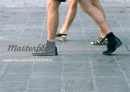 People walking, view from knees down, blurred.